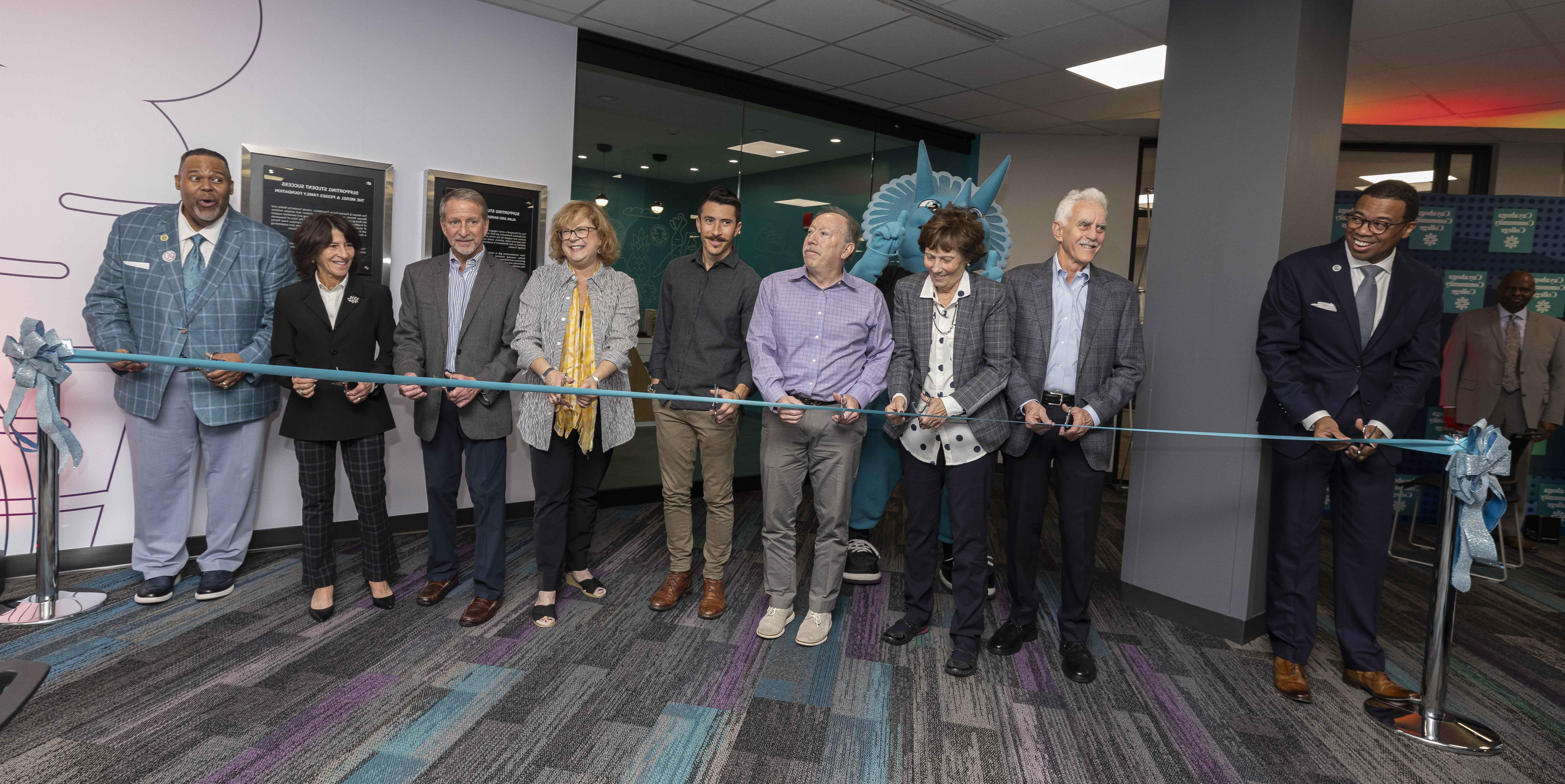 Line of individuals in business attire cutting a ribbon to dedicate the pantry space